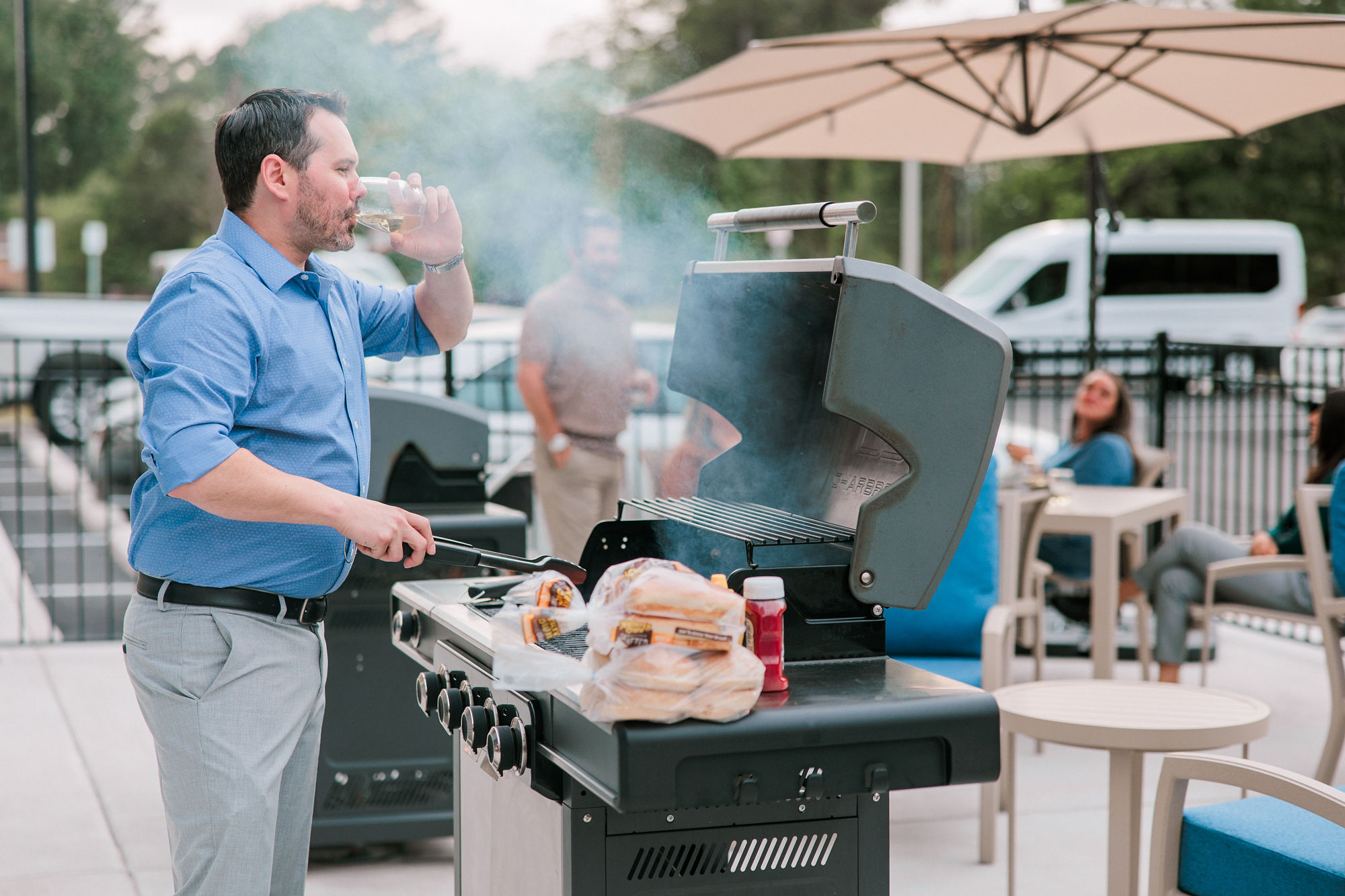 Guests enjoying an evening barbecue in the outdoor grilling area at YourSpace Hotels Chesapeake extended-stay hotel.