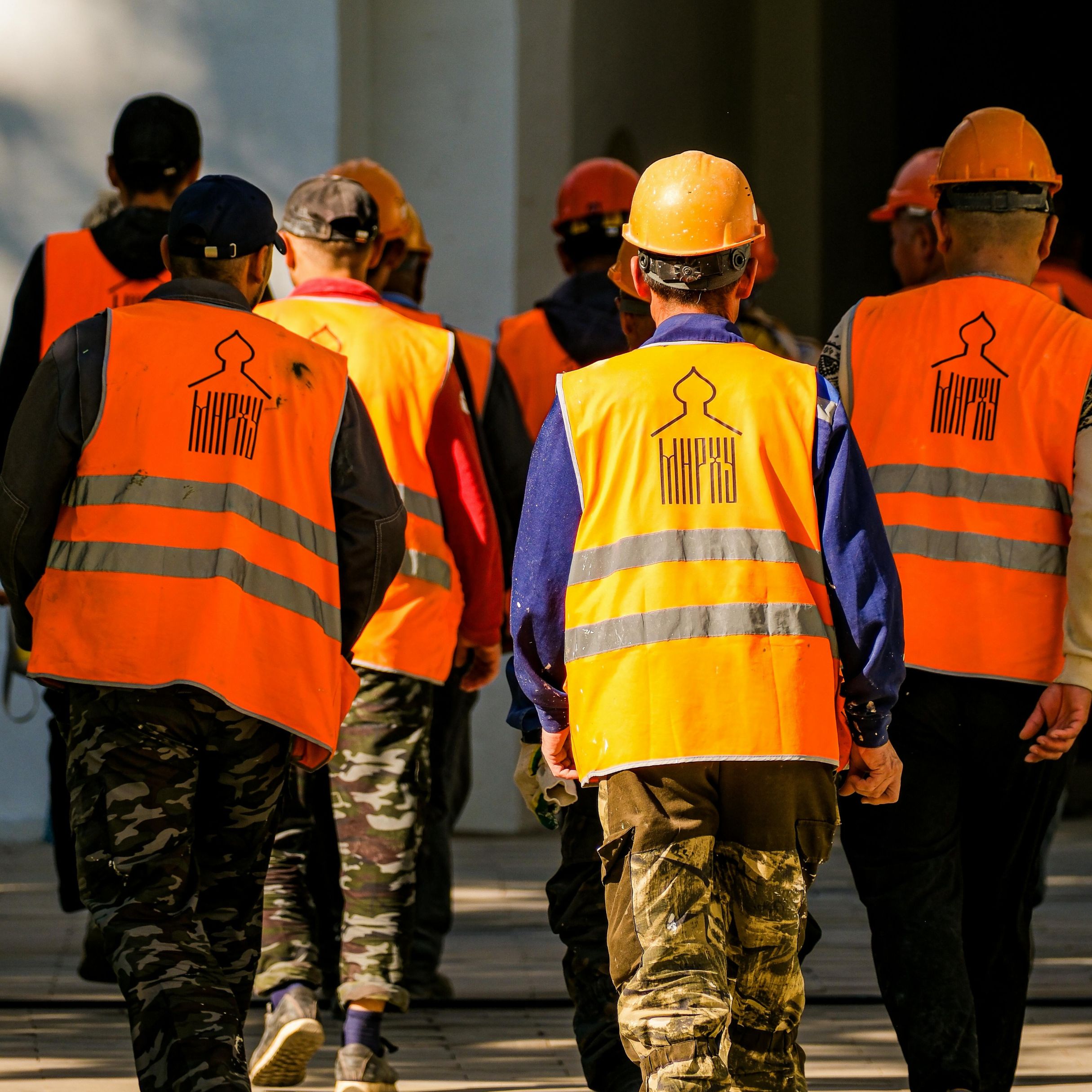 Safe, secure extended-stay lodging for construction and project crews in Chesapeake, VA. Construction workers relaxing outside YourSpace Hotels Chesapeake with work trucks parked safely nearby under well-lit, camera-monitored parking.